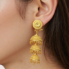 8mDqP1UiK1uNKvWRTKjBs57AY2a4cUSKR8SkczDa Triple-Tiered Gold Jhumka Earrings